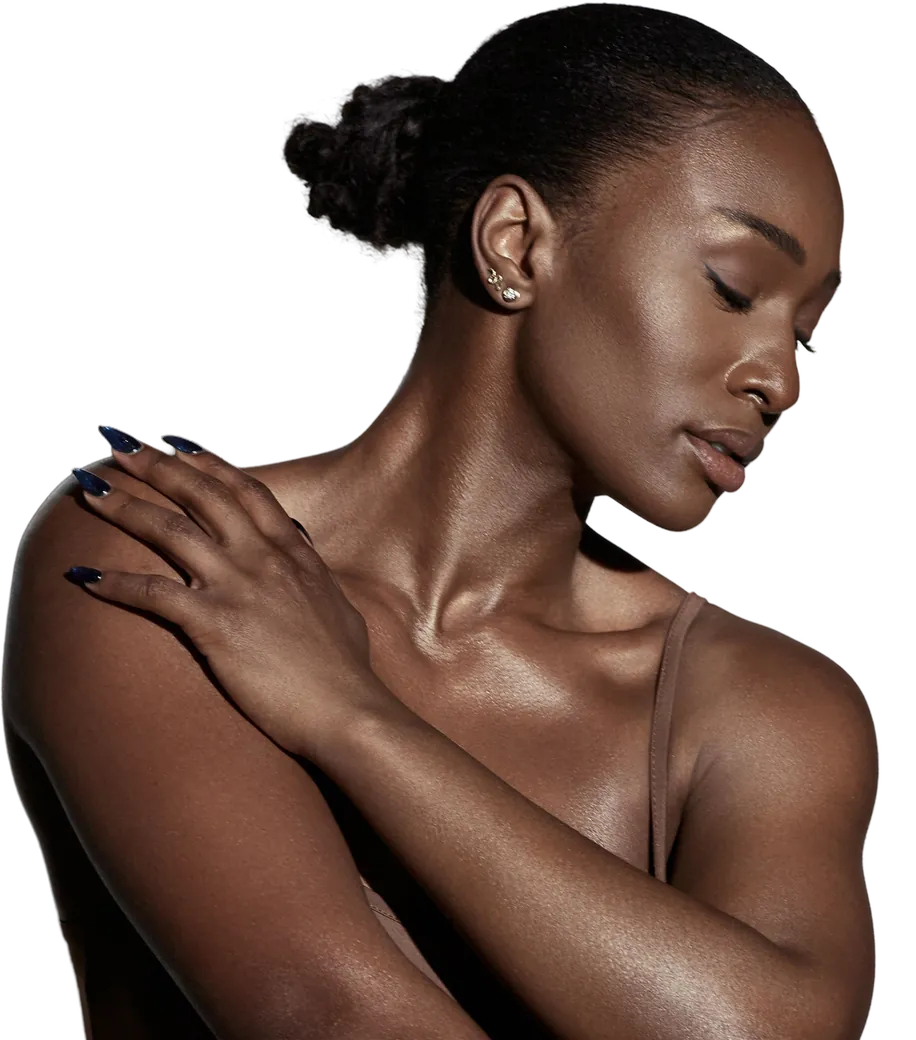 Woman with glowing skin resting a hand on her shoulder