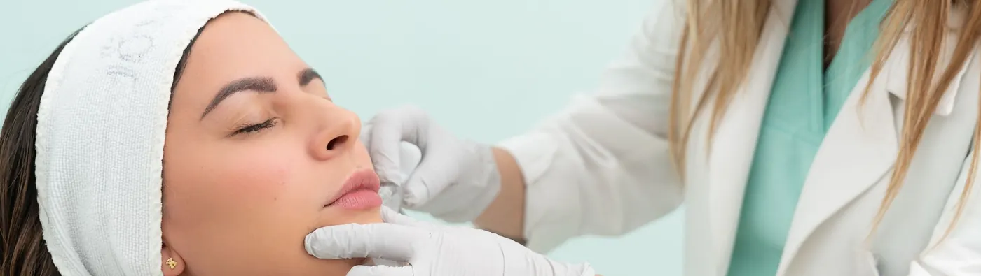 Provider injecting filler along a client's lower lip