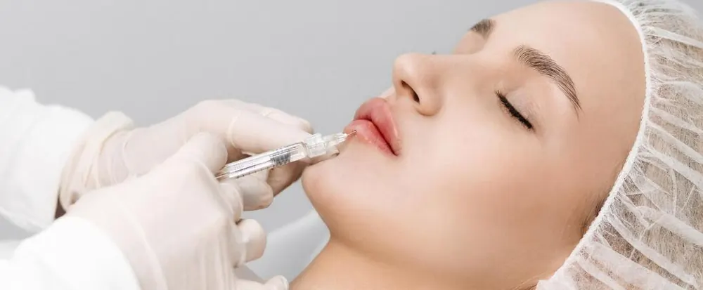 Provider injecting dermal filler into a client's lips