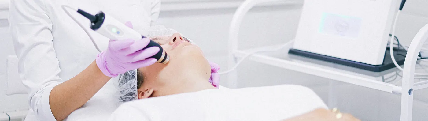 Provider treating a client's face with a skin tightening device