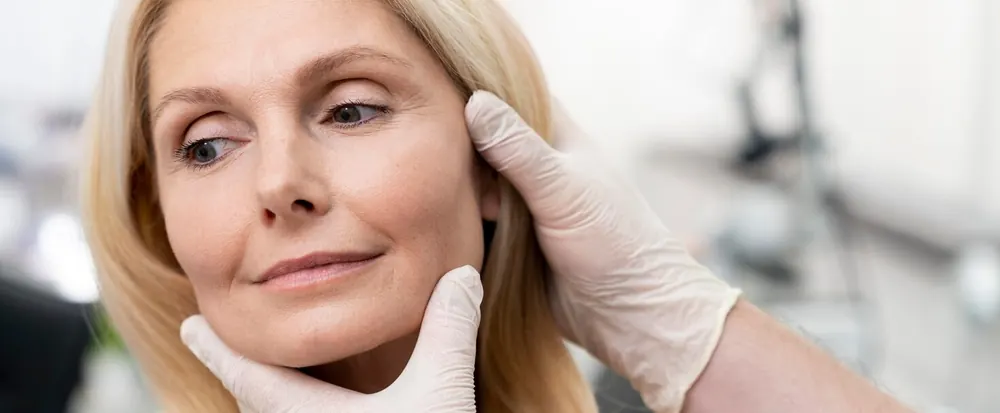 Provider examining a mature woman's jawline before Endolift