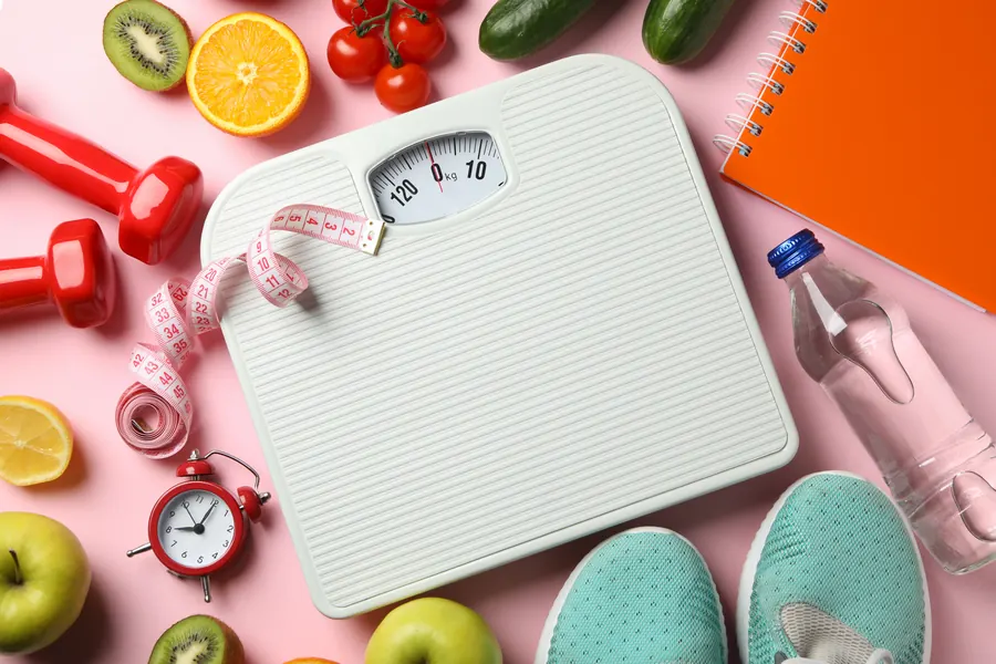 Scale, dumbbells, fruit and measuring tape for a weight management program