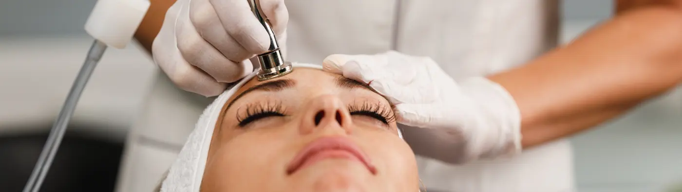 Microdermabrasion wand on a client's forehead
