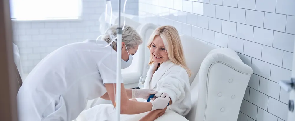 Nurse starting an NAD infusion for a smiling client